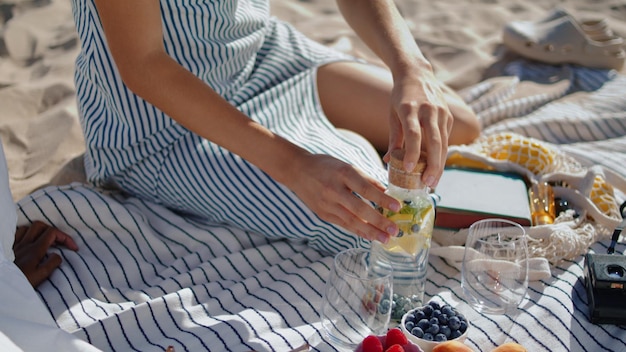 Closeup hands preparing picnic in sunlight relaxed girl pour water into glass