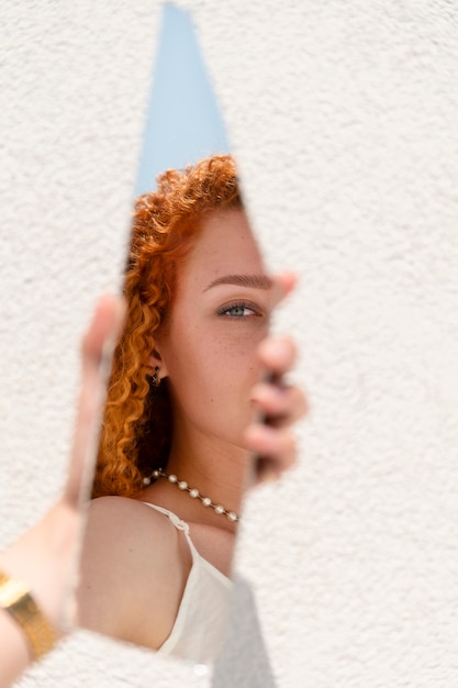 Young woman with mirror outside
